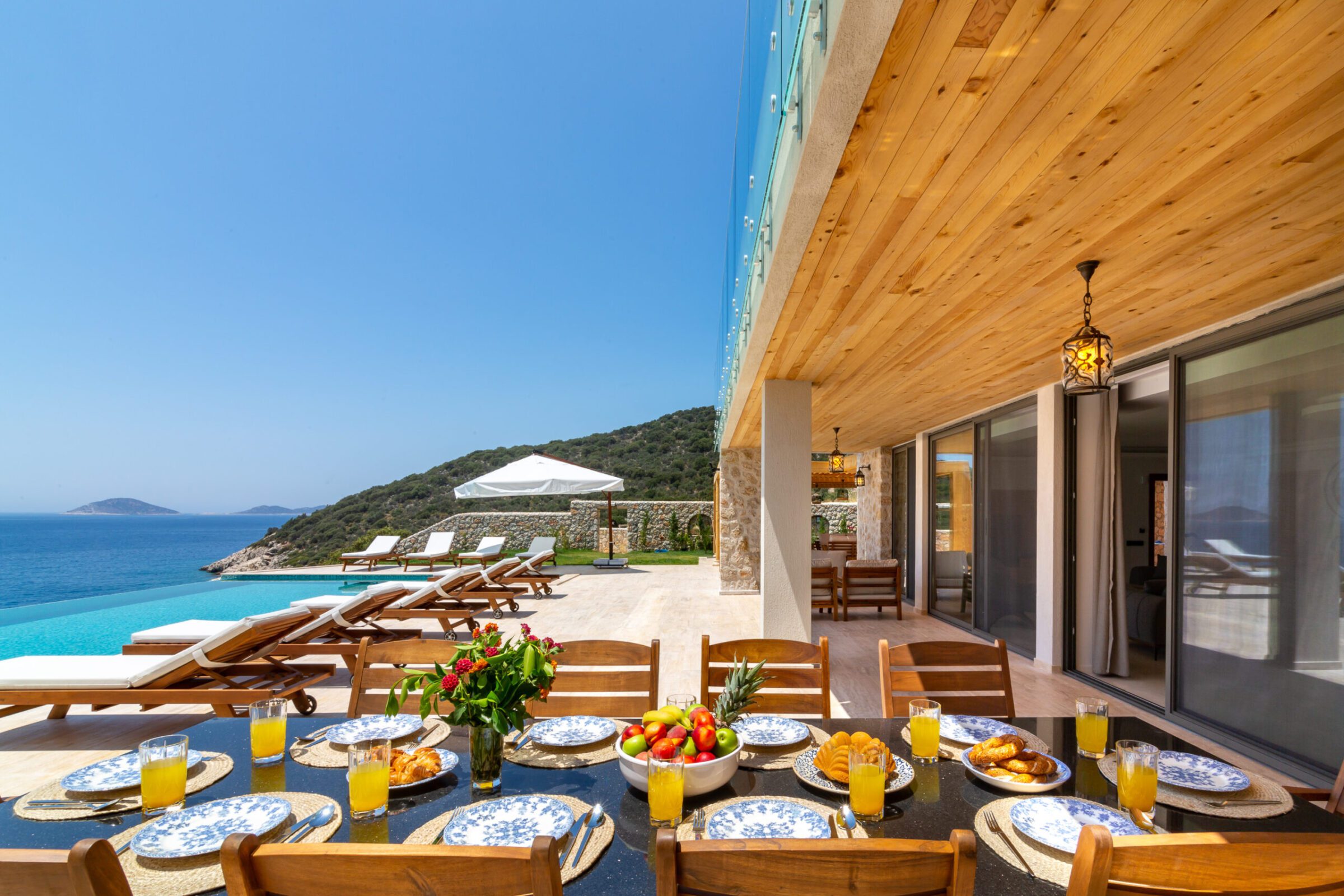 Outdoor dining table with sun loungers in Villa Water Edge 1, villas to rent in Kalkan, Turkey