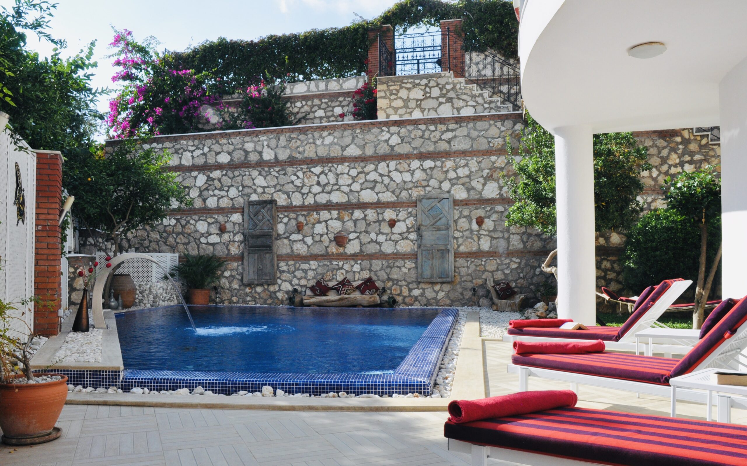 Outdoor pool and sun loungers at Villa Kirmizi Lale, holiday villas in Kalkan, Turkey